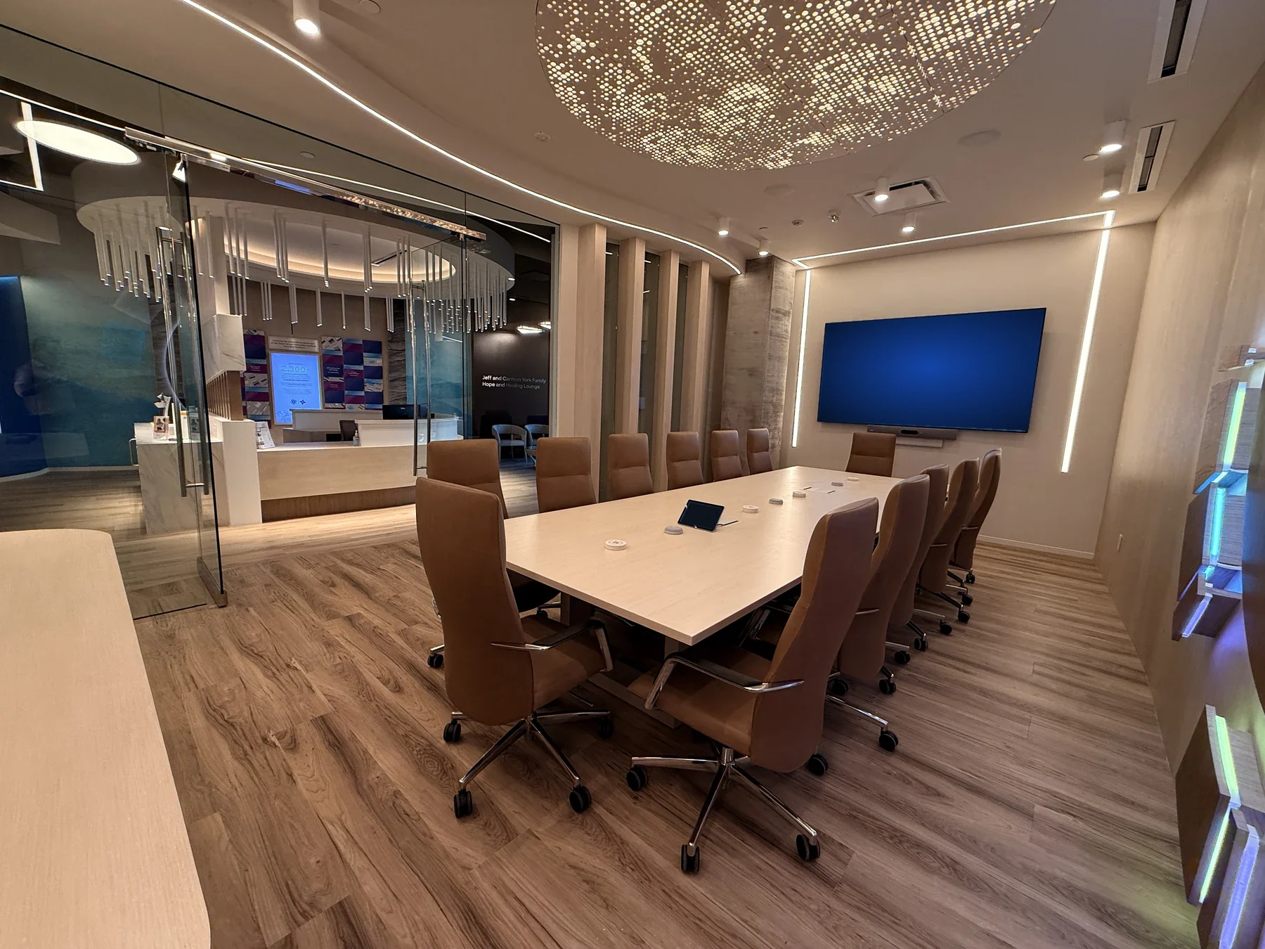 Conference table, display and microphones beside glass doors overlooking reception.