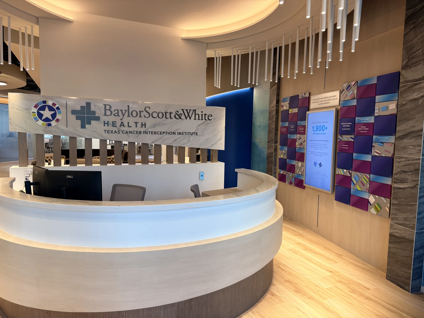 The institute entrance with Baylor Scott & White branding, a curved reception desk and the donor recognition display.