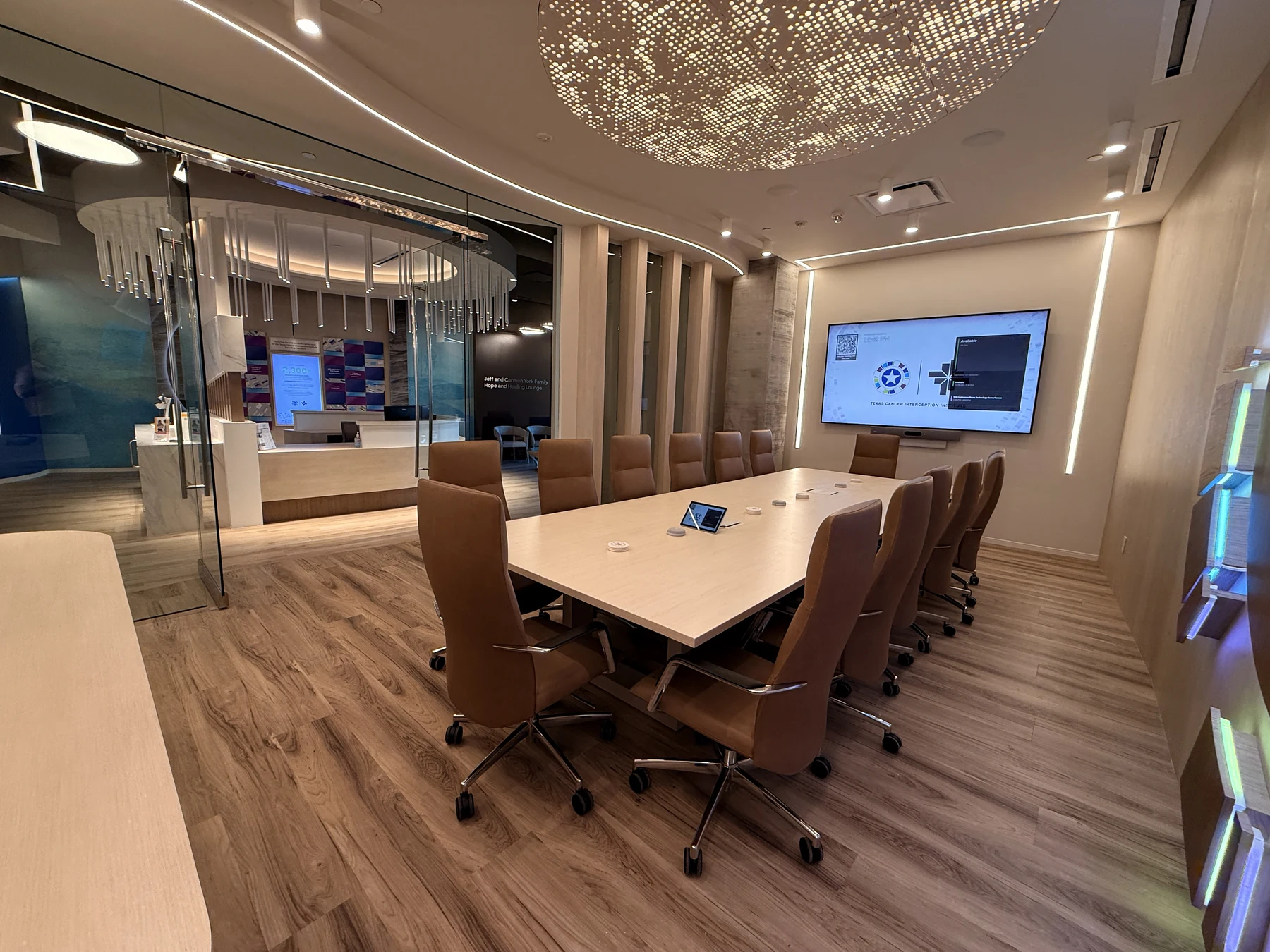 Conference table, display and microphones beside glass doors overlooking reception.
