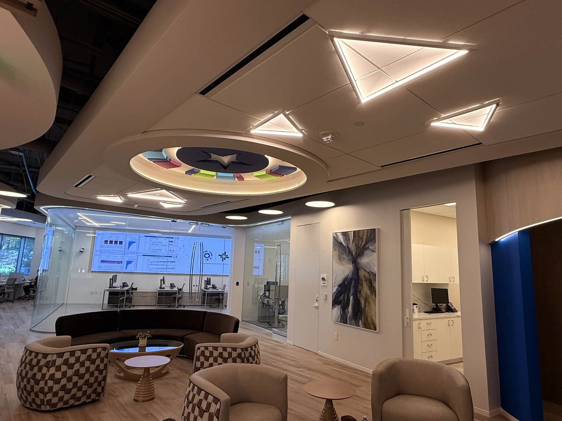 Shared seating beneath the institute emblem, with the glass-enclosed command center beyond.